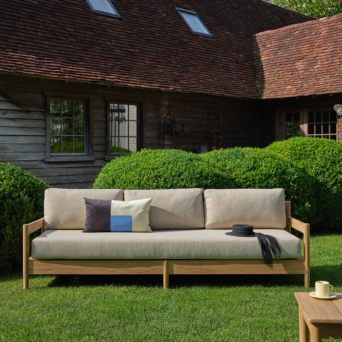 CALVI - Niedriges Gartensofa aus massivem Teakholz mit beige melierten Kissen, 4-Sitzer