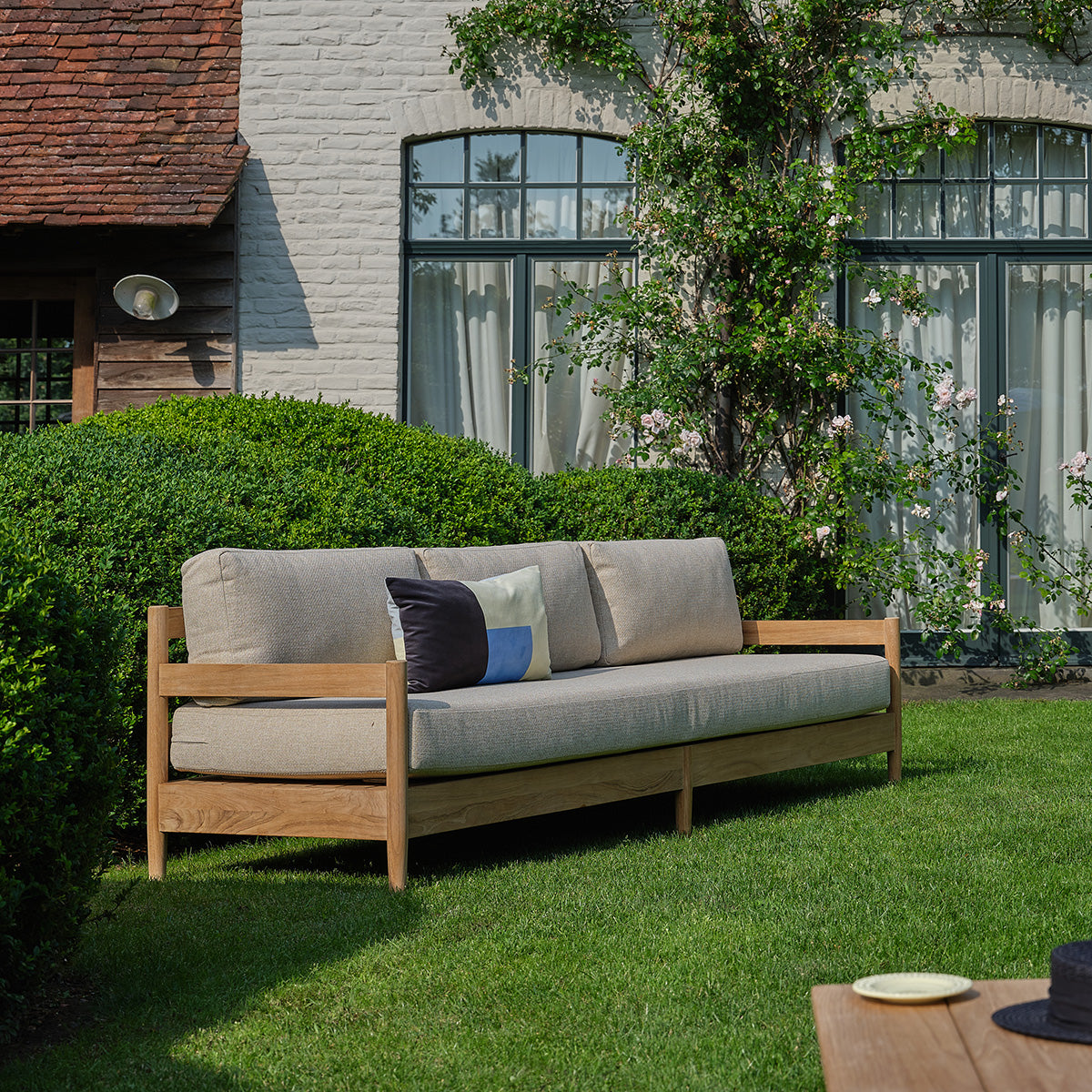 CALVI - Niedriges Gartensofa aus massivem Teakholz mit beige melierten Kissen, 4-Sitzer
