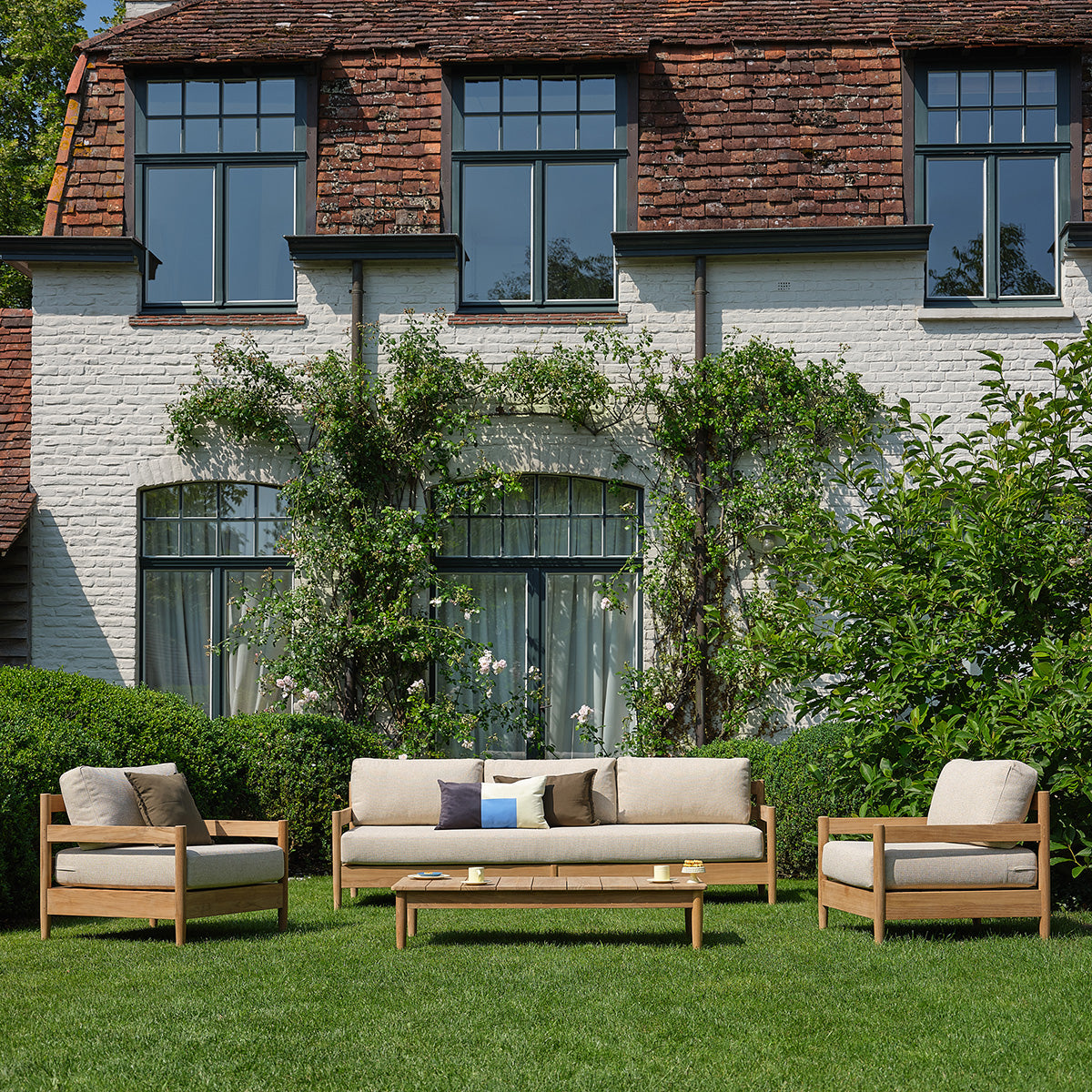 CALVI - Niedriges Gartensofa aus massivem Teakholz mit beige melierten Kissen, 4-Sitzer