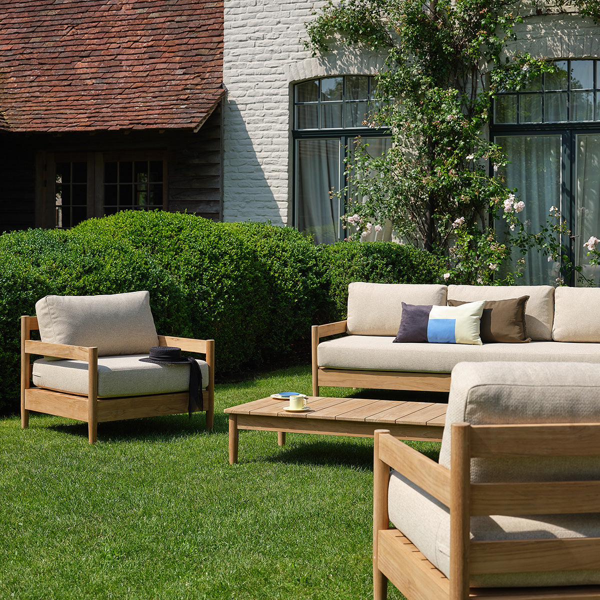 CALVI - Niedriges Gartensofa aus massivem Teakholz mit beige melierten Kissen, 4-Sitzer